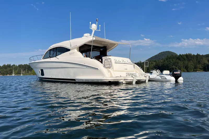 Dolce Far Niente Yacht Photos Pics 2012 Maritimo C53 Sports Cabriolet yacht on calm water with scenic forest backdrop.