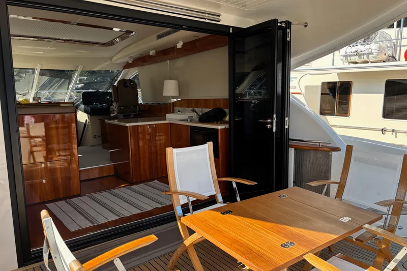 Dolce Far Niente Yacht Photos Pics Luxurious 2012 Maritimo C53 Sports Cabriolet yacht interior with wooden furnishings and outdoor seating.