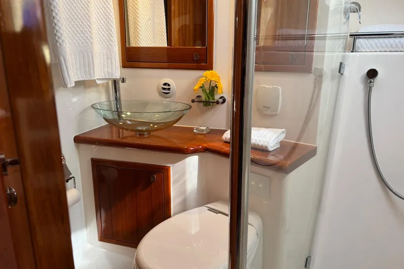 Dolce Far Niente Yacht Photos Pics Luxurious bathroom in 2012 Maritimo C53 Sports Cabriolet yacht with glass sink and wooden accents.