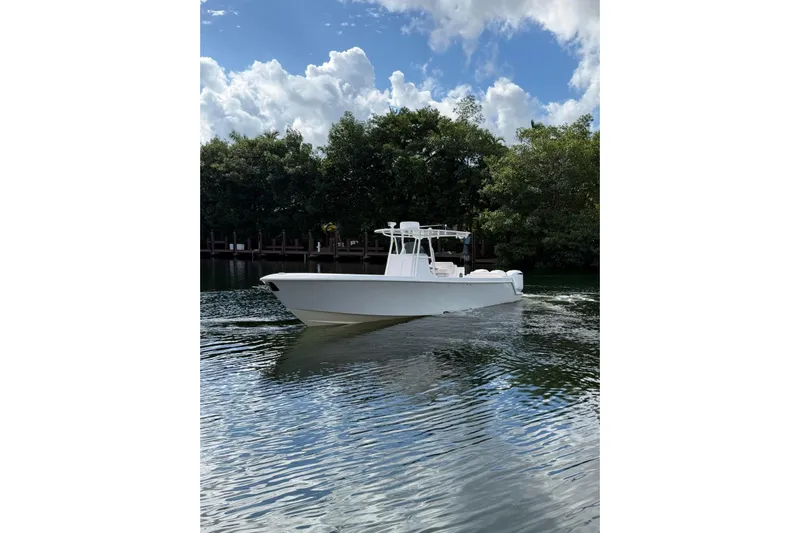  Yacht Photos Pics 2013 Contender 35 LS boat on calm water with lush greenery background.