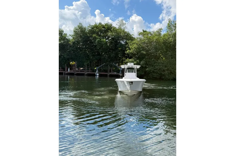  Yacht Photos Pics 2013 Contender 35 LS boat cruising on a calm river with lush greenery.