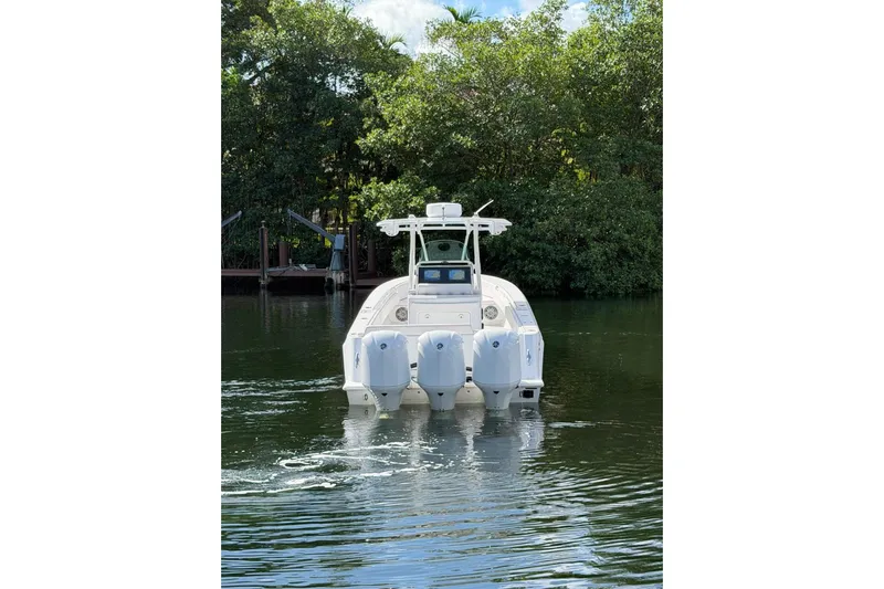  Yacht Photos Pics 2013 Contender 35 LS boat with triple engines on a calm waterway.