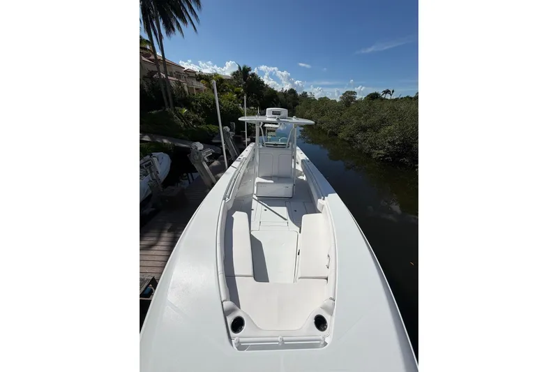  Yacht Photos Pics 2013 Contender 35 LS boat docked by lush greenery under clear blue sky.