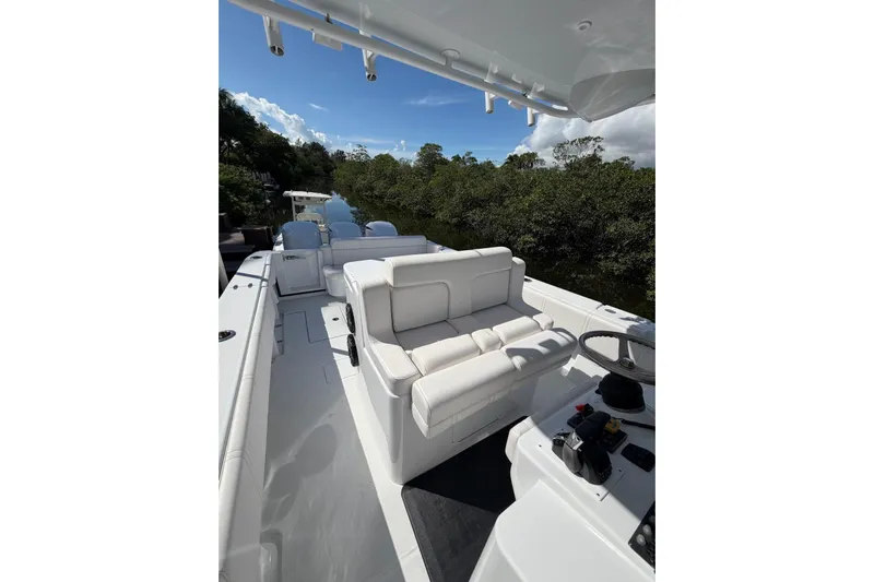  Yacht Photos Pics 2013 Contender 35 LS boat with white seating and steering, surrounded by lush greenery.