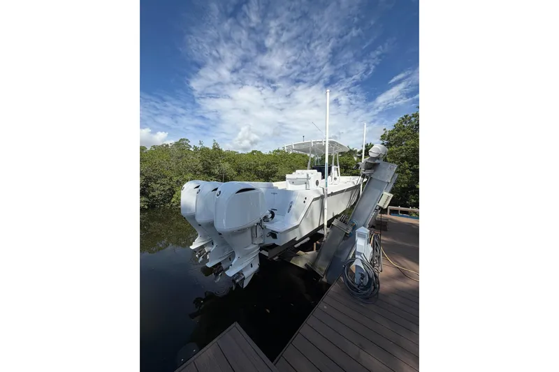  Yacht Photos Pics 2013 Contender 35 LS boat docked, featuring triple outboard engines under a clear blue sky.