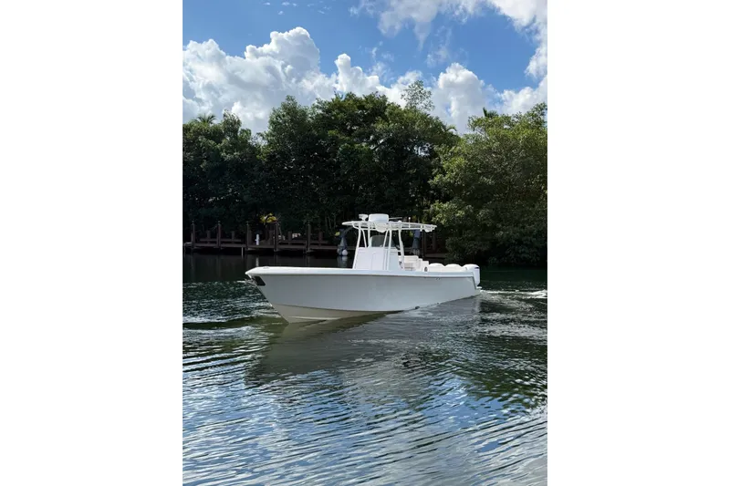  Yacht Photos Pics 2013 Contender 35 LS boat cruising on a calm river under a partly cloudy sky.