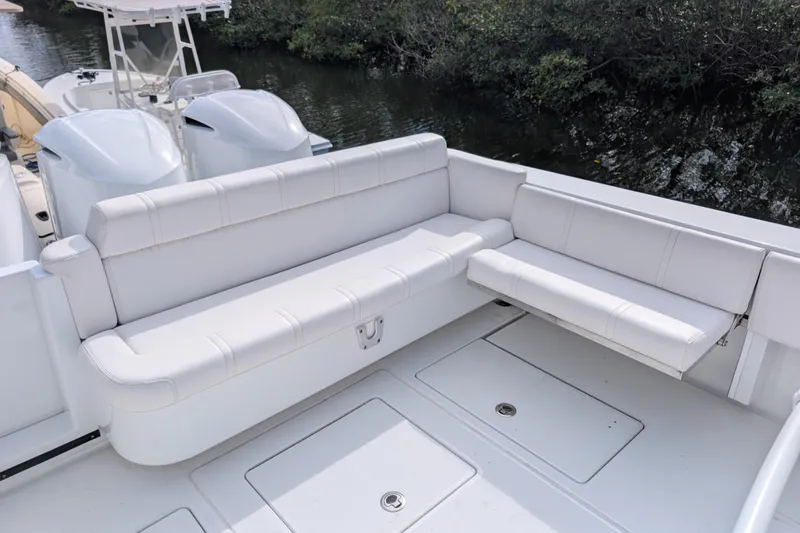  Yacht Photos Pics 2013 Contender 35 LS boat with white seating and dual engines, docked near greenery.