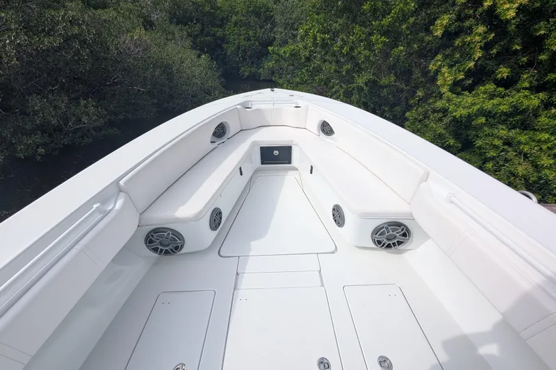  Yacht Photos Pics 2013 Contender 35 LS boat interior with white seating and speakers, surrounded by greenery.