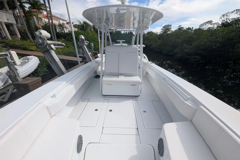  Yacht Photos Pics 2013 Contender 35 LS boat with spacious deck and seating, docked near lush greenery.