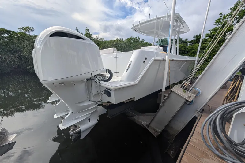  Yacht Photos Pics 2013 Contender 35 LS boat with outboard motor on lift by water.