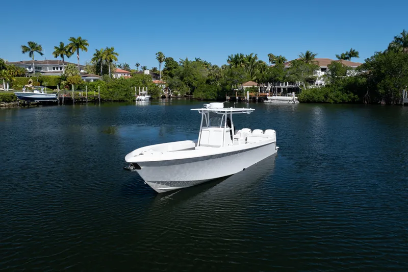  Yacht Photos Pics 2013 Contender 35 LS boat on a serene waterway with lush greenery and houses.