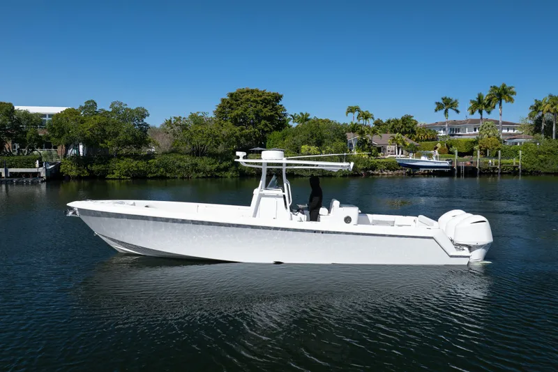  Yacht Photos Pics 2013 Contender 35 LS boat on calm water, surrounded by lush greenery and waterfront homes.