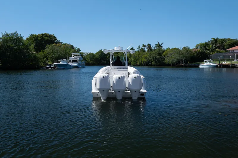  Yacht Photos Pics 2013 Contender 35 LS boat on a serene waterway, surrounded by lush greenery.