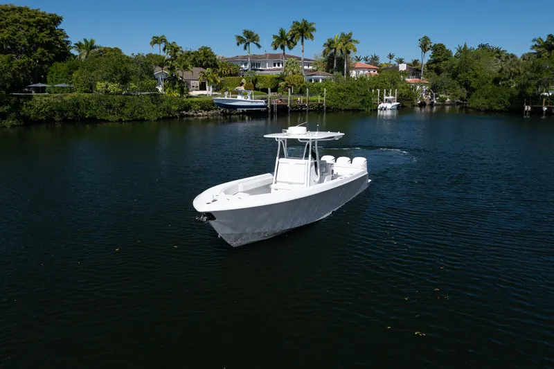  Yacht Photos Pics 2013 Contender 35 LS boat cruising on a serene waterway with lush greenery.