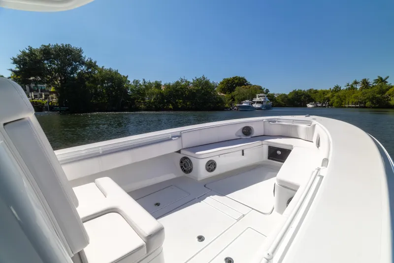  Yacht Photos Pics 2013 Contender 35 LS boat interior with white seating, on a calm waterway.