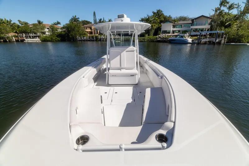  Yacht Photos Pics 2013 Contender 35 LS boat on calm water, surrounded by lush greenery and waterfront homes.