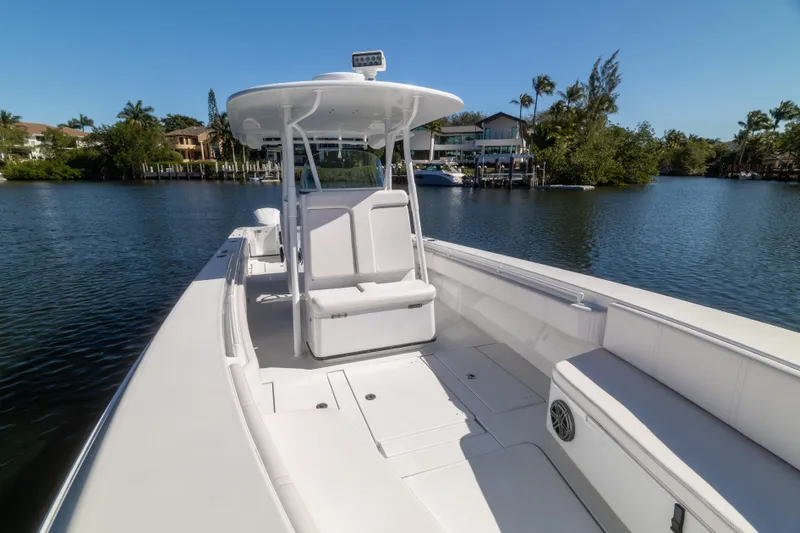  Yacht Photos Pics 2013 Contender 35 LS boat on calm water, surrounded by lush greenery and waterfront homes.