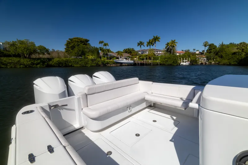  Yacht Photos Pics 2013 Contender 35 LS boat with white seating, docked near lush greenery and waterfront homes.