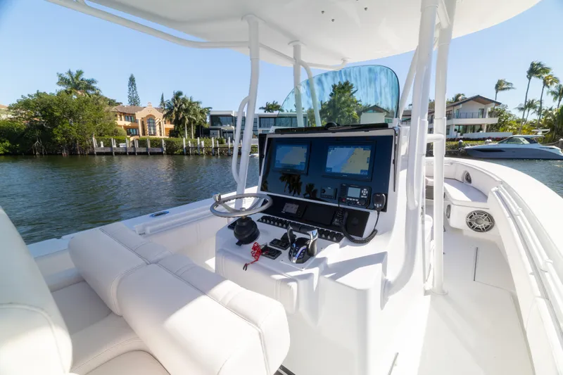  Yacht Photos Pics 2013 Contender 35 LS boat cockpit with modern navigation system, docked near waterfront homes.