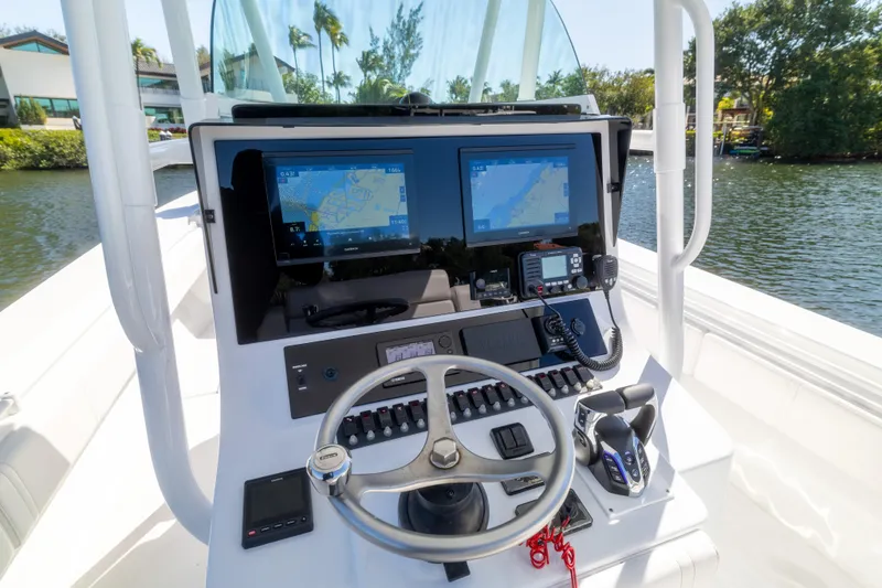  Yacht Photos Pics Control panel of a 2013 Contender 35 LS boat with navigation screens and steering wheel.