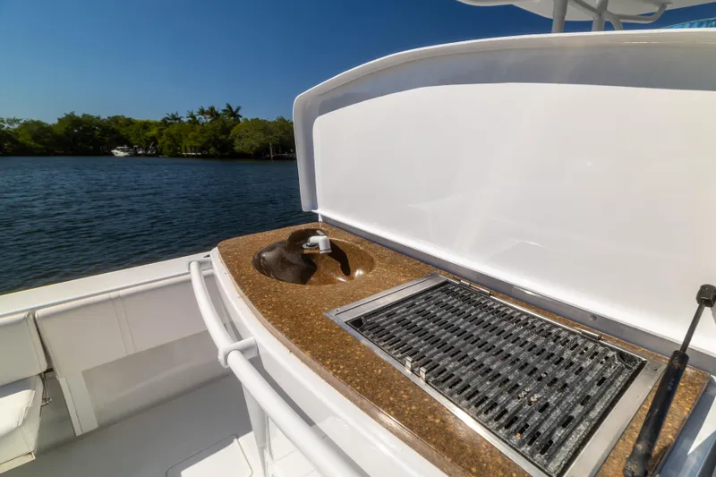  Yacht Photos Pics 2013 Contender 35 LS boat with outdoor grill and sink, docked by a scenic lake.