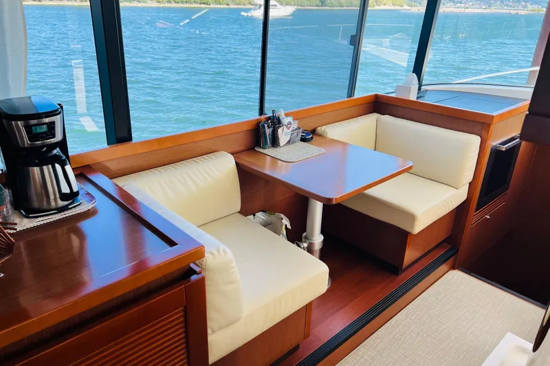 Billy Yacht Photos Pics Interior of 2014 Beneteau Swift Trawler 50 with dining area and coffee maker.