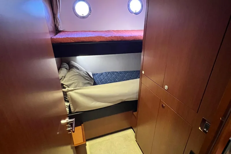Billy Yacht Photos Pics Bunk beds in 2014 Beneteau Swift Trawler 50 cabin with wooden interior and porthole.