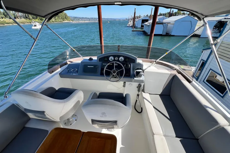 Billy Yacht Photos Pics 2014 Beneteau Swift Trawler 50 helm with dual seats, overlooking marina and water.