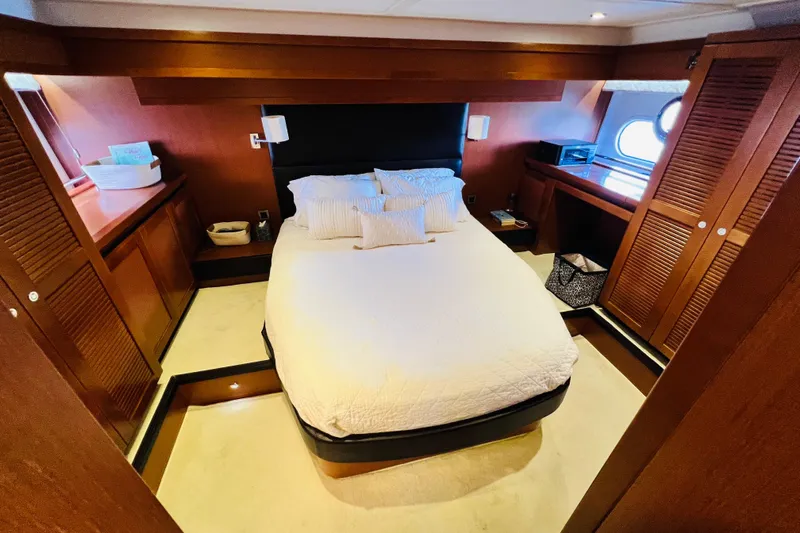 Billy Yacht Photos Pics Luxurious bedroom in 2014 Beneteau Swift Trawler 50 yacht, featuring elegant wood finishes.