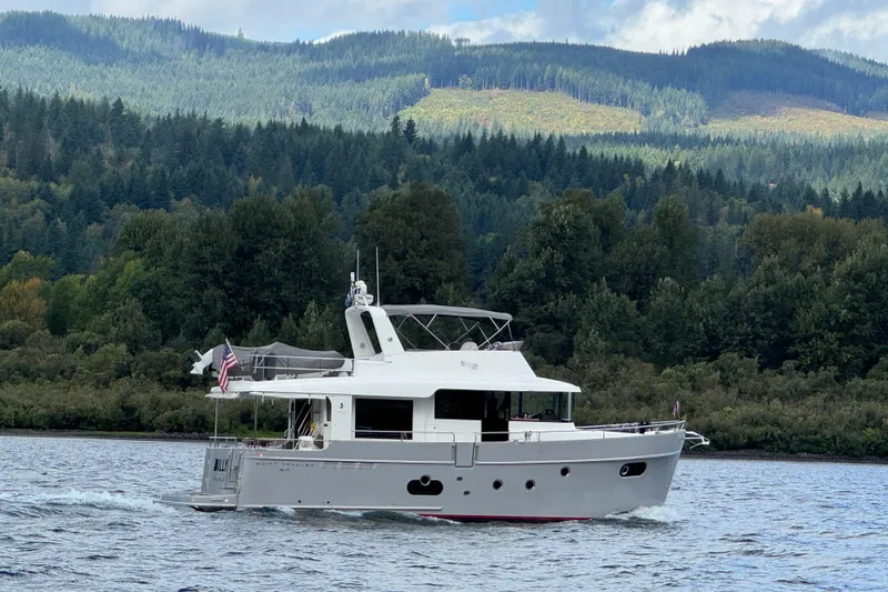 Billy Yacht Photos Pics 2014 Beneteau Swift Trawler 50 cruising on a scenic lake with forested hills.