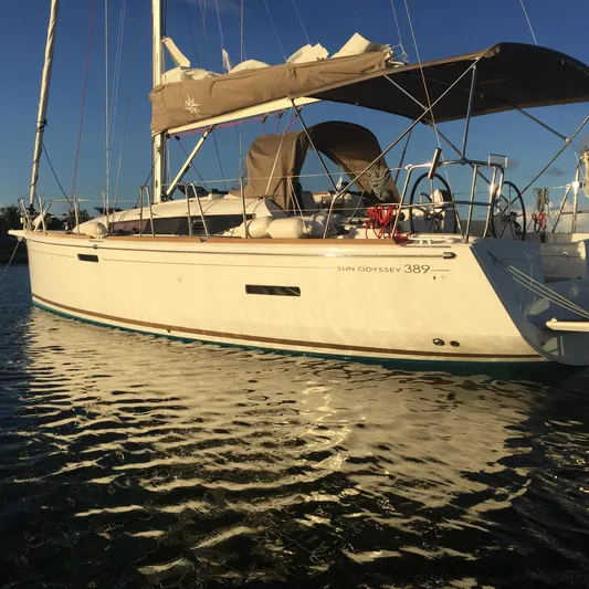  Yacht Photos Pics 2017 Jeanneau Sun Odyssey 389 sailboat on calm water at sunset.