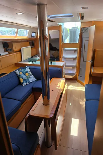  Yacht Photos Pics Interior of 2017 Jeanneau Sun Odyssey 389 sailboat with blue seating and wooden finishes.