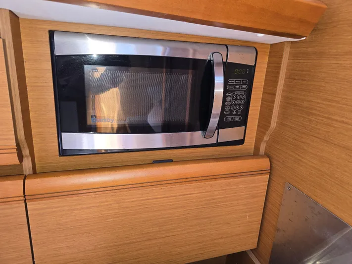  Yacht Photos Pics Microwave in 2017 Jeanneau Sun Odyssey 389 yacht kitchen, wood cabinetry.