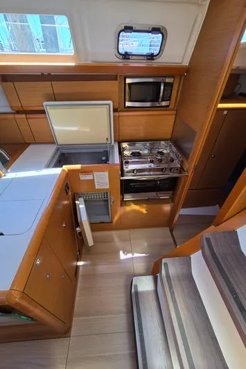  Yacht Photos Pics 2017 Jeanneau Sun Odyssey 389 interior kitchen with stove, fridge, and microwave.
