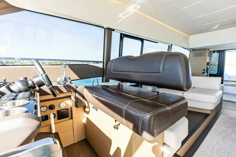 Anna Louise Yacht Photos Pics Luxurious interior of 2022 Prestige 590 Flybridge yacht with leather seating and modern controls.
