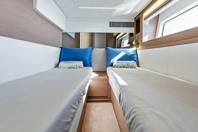 Anna Louise Yacht Photos Pics Luxurious twin cabin interior of 2022 Prestige 590 Flybridge yacht with blue accents.