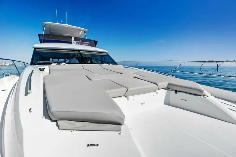 Anna Louise Yacht Photos Pics 2022 Prestige 590 Flybridge yacht with sunbathing area on deck, ocean view.
