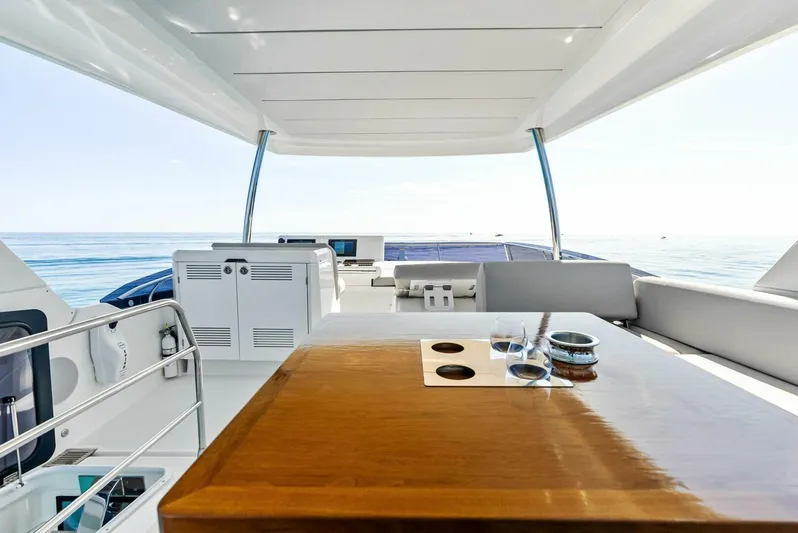 Anna Louise Yacht Photos Pics Luxurious 2022 Prestige 590 flybridge yacht with elegant wooden table and ocean view.