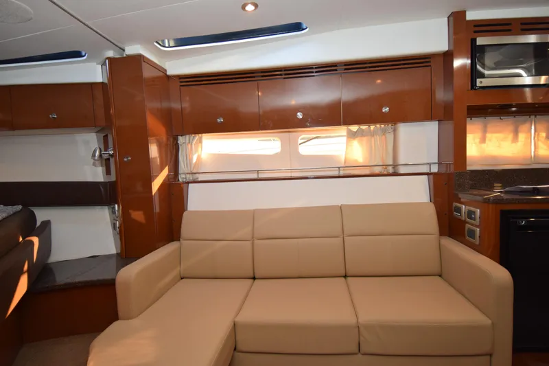 Just Plane Fun Yacht Photos Pics Luxurious interior of 2014 Sea Ray 350 Sundancer yacht with beige sofa and wood finishes.