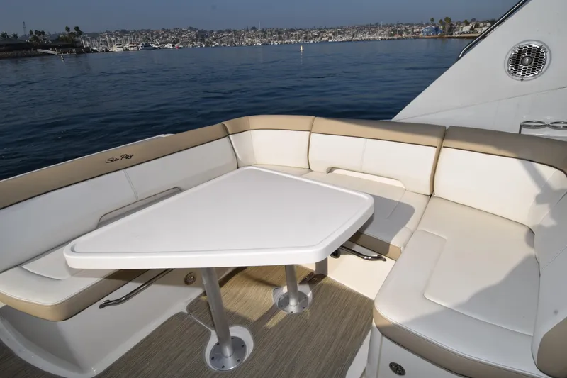 Just Plane Fun Yacht Photos Pics 2014 Sea Ray 350 Sundancer boat with cushioned seating and table, overlooking a scenic harbor.