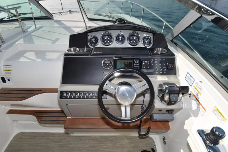 Just Plane Fun Yacht Photos Pics 2014 Sea Ray 350 Sundancer helm with gauges and controls, featuring a sleek steering wheel.
