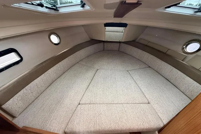 Skylark Yacht Photos Pics 2025 Ranger Tugs R23 cabin interior with cushioned seating and porthole windows.