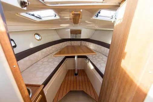 Skylark Yacht Photos Pics 2025 Ranger Tugs R23 cabin interior with seating and table, featuring skylights and wood accents.