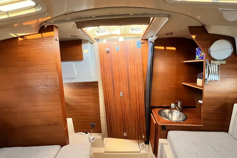 Skylark Yacht Photos Pics 2025 Ranger Tugs R23 cabin interior with wood finish, sink, and storage shelves.