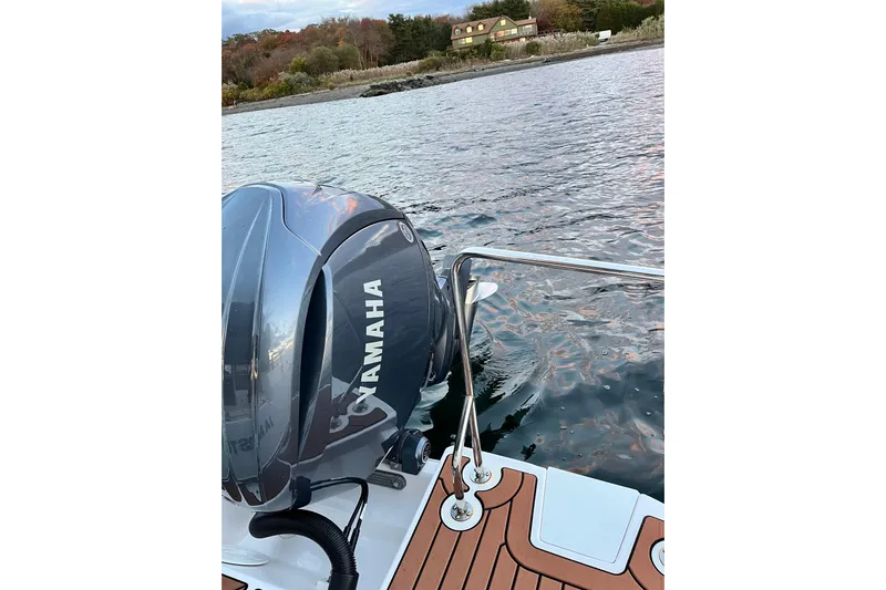 Skylark Yacht Photos Pics 2025 Ranger Tugs R23 with Yamaha outboard engine on calm water near shoreline.