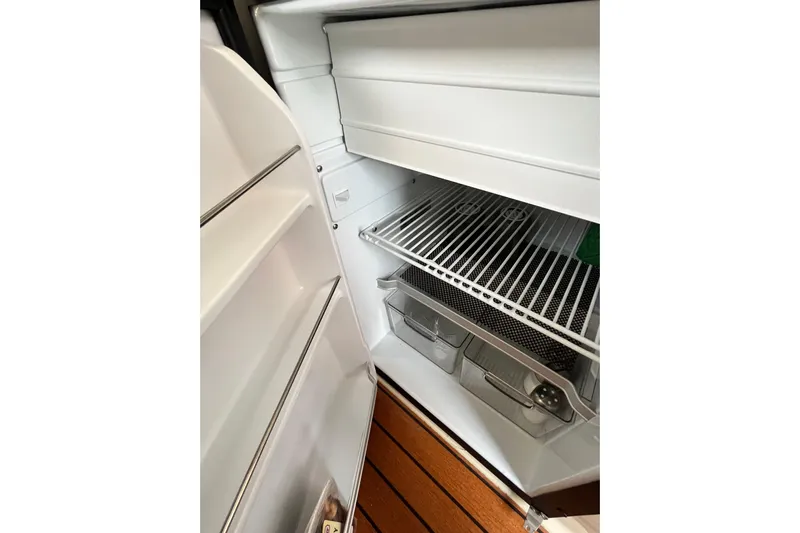 Skylark Yacht Photos Pics Open refrigerator inside 2025 Ranger Tugs R23 boat, showcasing shelves and storage compartments.