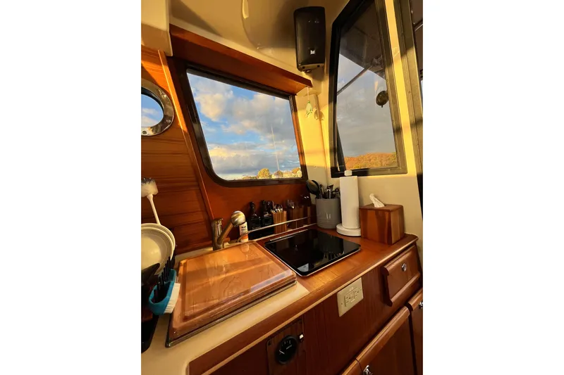 Skylark Yacht Photos Pics Cozy kitchen interior of 2025 Ranger Tugs R23 boat with wooden cabinetry and scenic window view.