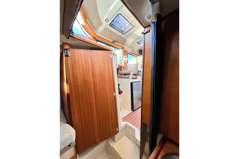 Skylark Yacht Photos Pics Interior view of 2025 Ranger Tugs R23 boat, featuring wooden cabinetry and seating area.