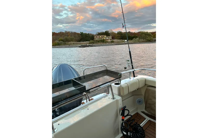 Skylark Yacht Photos Pics 2025 Ranger Tugs R23 boat with fishing gear on a serene lake at sunset.