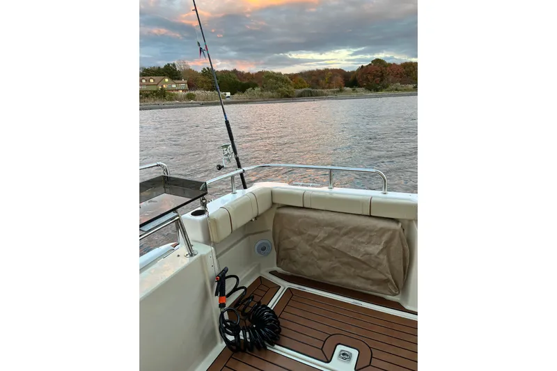 Skylark Yacht Photos Pics 2025 Ranger Tugs R23 boat interior with fishing rod, scenic river view.